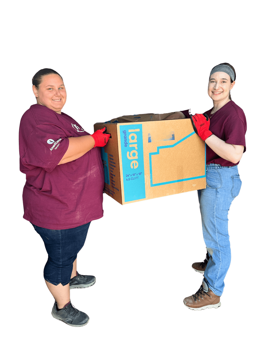 Two volunteers at ReSOURCE in maroon shirts and gloves, collaboratively carrying a large donation box, exemplifying the teamwork involved in ReSOURCE's poverty and flood relief efforts in Barre, Vermont.